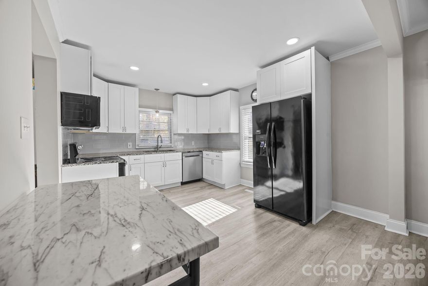 211 Franklin Ave is an updated single-family home conveniently located just minutes from downtown Kannapolis with quick access to Interstate 85, Highway 29, and Mooresville Road, making daily commuting simple and efficient. This 1940 mill home offers thoughtful interior updates presents a solid opportunity for first-time buyers, downsizers, or anyone seeking a move-in-ready home at an approachable price point. Inside, vinyl plank flooring runs throughout the home, creating a clean and cohesive feel. The kitchen features white shaker-style cabinetry with polished chrome hardware, granite countertops, and a full appliance package including a stove, refrigerator, microwave, and dishwasher, with the dishwasher replaced in 2026. The bathroom includes a large solid-surface vanity with an under-mount sink, and a dedicated laundry area with stackable washer and dryer units adds everyday convenience. Situated on a corner lot, the property offers a welcoming front porch, a back deck, and a privacy-fenced backyard. A 10x16 storage building provides additional space for tools or equipment, while a Ring doorbell adds a modern touch. With its manageable size, practical updates, and convenient location near downtown and major commuter routes, 211 Franklin Ave offers a smart and affordable option in the heart of Kannapolis.