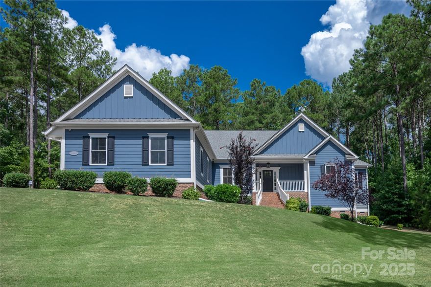 Nestled within the coveted gated community of Riverchase Estates along the scenic Catawba River, this stunning single-level residence offers refined living in a serene, wooded setting. Main living spaces seamlessly flow into the open-concept dining and living areas designed for effortless entertaining. The gourmet kitchen showcases a sprawling island, double ovens, and generous cabinetry. The luxurious primary suite features a spa-inspired bath and expansive walk-in closet. Secondary bedrooms and office offer the perfect opportunity for today's modern buyer with flexible spaces. A true highlight is the covered deck with a stone fireplace, offering a tranquil retreat surrounded by nature. Plus, this home features a whole house Generac generator. Residents enjoy exclusive access to resort-style amenities including a 6-acre Lakeside Park, pool, clubhouse, state-of-the-art fitness center, and miles of hiking trails with over 500 acres of protected natural preserve.