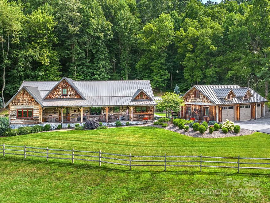 Tucked away in the beautiful Smoky mountains of Waynesville, just moments to historic Main St, this stunning equestrian estate offers the ultimate in luxury living. Featuring timeless rustic post and beam construction, the home is as functional as it is elegant. The spacious kitchen is designed for gourmet cooking, complete with a deep copper sink and leathered granite countertops. The luxurious primary suite boasts a soaking tub for a spa-like retreat. Enjoy the serene mountain views on over 21 unrestricted acres from the charming farmhouse front porch.  Relax year-round on the screened back porch. Perfect for horse enthusiasts, this property includes well-appointed 89X50 Morton barn with 3 stalls, wash rack and tack room- topped off by grazing pastures, and a scenic creek. Additional features include a workshop, multiple garages, and a carport for your horse trailer. This exceptional property blends elegance, comfort, and equestrian living in an unmatched mountain setting.