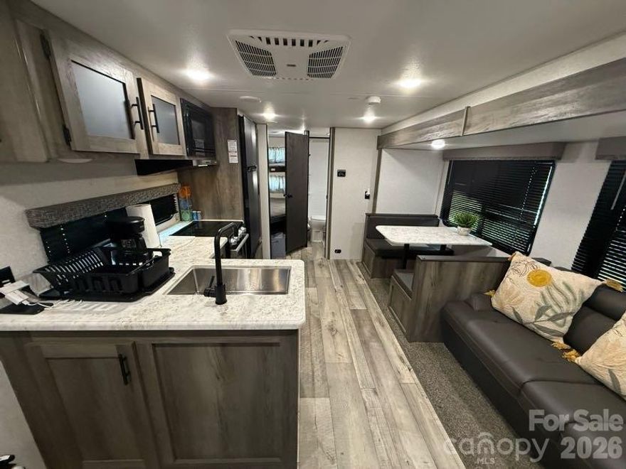 Welcome to your new lake property; perfect for owners who love to fish, get away from city life, and overall enjoy the outdoors!

Badin Shores Resort is a private, gated community that includes access to a pool (seasonal), lake, fishing piers, playgrounds and more. This lot includes a stationary fully furnished camper, a newly refinished deck with outdoor furniture, and an electric golf cart. Personal property (camper and golf cart) will transfer with a bill of sale, but is included in the purchase price.

The camper includes a queen size bed in a private room and twin bunk beds off the kitchen/living area. TVs in both areas will convey. The bathroom includes a standing shower. Full kitchen with a seating area for four and a comfortable love seat that extends into an additional bed round out the amenities of the camper. 

All decor, furnishings, linens, televisions, and accessories within the property and on the deck will remain after sale.