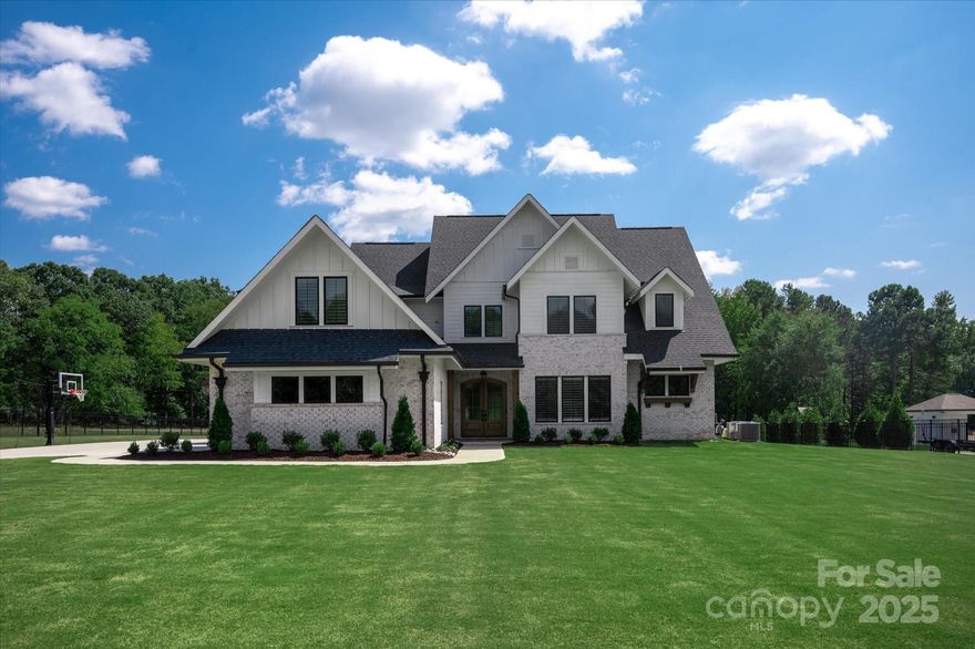 New luxury home located in the Marvin school district on a gorgeous 1.3 acre lot. This 2024 custom built home offers massive front and back yards and an oversized extended driveway, all secured by a private front entry gate. Lovely floor plan features a primary on main, dedicated office with custom wall details and gorgeous Great Room with beautiful coffered ceiling detail and designer white washed stone fireplace. Light and bright interior includes luxurious 7" white oak hardwood flooring on main and second floor main areas, designer lighting, custom built ins, casement windows and plantation shutters. Chef's kitchen includes many tasteful features such as a built in fridge, two dishwashers, 48" dual fuel KitchenAid 6 burner range with commercial hood, 9ft white oak island, toe kick + under counter cabinet lighting and a convenient scullery pantry. Main floor also features a beautiful primary bedroom with luxury spa bath including oversized shower with dual shower heads + rainhead. The primary closet includes thoughtfully designed cabinetry plus a washer and dryer hookup. Upstairs includes 3 nice size secondary rooms plus 2 bonus rooms, a media room with wiring for 7 point surround sound, an oversized flex space perfect for a home gym and additional flex space great for a second office or gaming room. Take in the great North Carolina weather on the generous covered rear porch with an outdoor fireplace and radiant porch heaters built in overhead for year round enjoyment. No need to worry about parking as the ultra wide driveway provides more than enough room for friends and family. Other great features include oversized 3 car garage with epoxy flooring and custom built in cabinetry and wall system, tankless hot water heater, lighted stair treads, mahogany double front doors, full irrigation and retractable sliding doors in Great Room. Move in Ready!