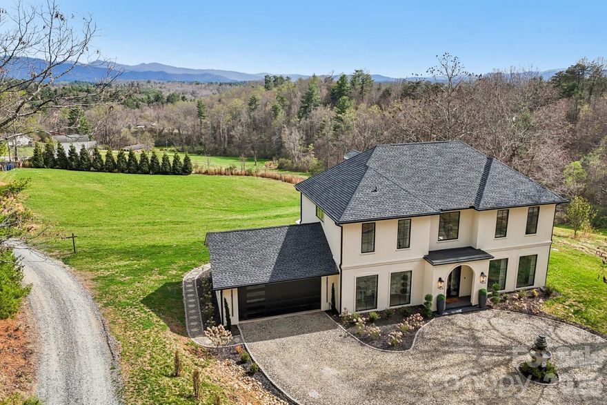 This uniquely constructed French Provincial estate blends timeless European charm with sleek contemporary design, set on 2.1 acres of cleared land with sweeping year-round long-range mountain views. With 3,444 square feet of refined living space, this 3-bedroom plus home office, 2.5-bath residence offers a harmonious balance of craftsmanship, elegance, and comfort, welcoming guests via a circular driveway complemented by a serene fountain. Entering the home, a front salon creates the ideal receiving room with a glass-enclosed wine display and face-to-face seating, adjacent to a formal elongated dining area that sets the tone for sophisticated entertaining. The main living area centers around an elegant spiral staircase and a striking floating ethanol gel-fueled fireplace, with boxed bay windows capturing timeless views of rolling pastures and the soft hues of the Blue Ridge Mountains. The kitchen is enhanced by a breakfast island, glass cabinetry, an abundant butler's pantry, and undercabinet lighting that illuminates every workspace. The primary suite is a private sanctuary highlighted by a lavish master closet with under-lit glass display cases worthy of a boutique, alongside a primary bathroom featuring a sink island, floating mirrors, a touchless sensor commode, an elegant freestanding soaker tub, and a separate grout-free quartzite shower stall. Pull-down stairs lead to finished attic space with remote-control lighting, completing this masterpiece that offers a rare fusion of old-world grace and modern luxury, crafted for those who appreciate both artistry and innovation in design.