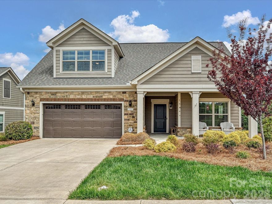 Spacious luxury story-and-a-half home designed for easy main-level living. The main floor includes the primary suite, secondary bedroom, two full baths, office/den with French doors, great room, kitchen, and dining area. The second floor is ideal for guests or entertaining with an additional bedroom, large bonus room, full bath, and storage. Enjoy the private fenced side patio with pavers, conveniently located off the great room and dining area—perfect for relaxing or gathering with friends. Turf has been added for beautiful, low-maintenance green space year-round. The kitchen offers numerous white cabinets, a spacious island, walk-in pantry, 5-burner gas cooktop, wall oven, and microwave/convection oven, creating a wonderful space for both everyday living and entertaining. The great room features gas logs and built-in shelving.The split-bedroom layout provides privacy. The spacious primary suite includes an expanded sitting area, tray ceiling, and luxury bath with walk-in shower, dual sinks, private water closet, linen closet, and large walk-in closet. A private secondary bedroom and full bath are also located on the main level. Located in The Courtyards at Wesley Chapel, an active and welcoming community offering a pool, pickleball courts, clubhouse, fitness center, walking trails, holiday gatherings, and community clubs. Convenient to nearby shopping and restaurants.