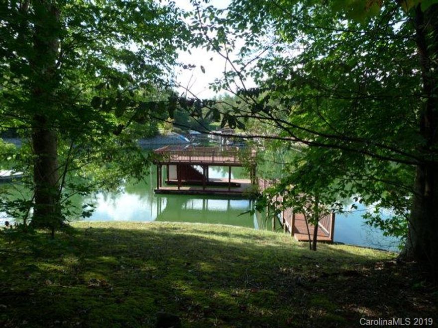 Gently sloping waterfront lot--cleared and grassed to the water! Over 123 feet of waterfrontage with keystone block wall. Covered dock with one slip in composite decking. Deep water cove with view to the mountains. Top deck perfect for enjoying the sun. City water available, septic needed. Ready to build on!  $150/year HOA dues are voluntary. Lot #11