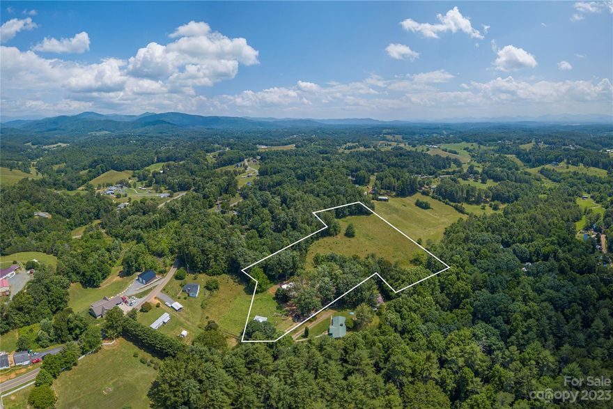 8.1 acres of rolling slope and pasture located 20 minutes from Asheville provides a beautiful setting for a buyer looking to create their dream home and utilize the land for livestock. The unfinished home has insulated windows installed and a metal roof. Additionally, the electric wiring has been started and is currently plumbed for 2 full baths and has 2 oversized garage doors on 2 levels allowing the buyer to customize and design the dwelling according to their preferences and needs. Semi-private and situated off the main road offers a sense of seclusion and tranquility. Peaceful living environment away from the hustle and bustle of urban areas. The open pasture behind the main dwelling adds an extra layer of privacy, creating a secluded retreat for the homeowners. The land's suitability for livestock is a significant advantage, as it provides ample space for grazing and potentially even the expansion of the livestock operation.