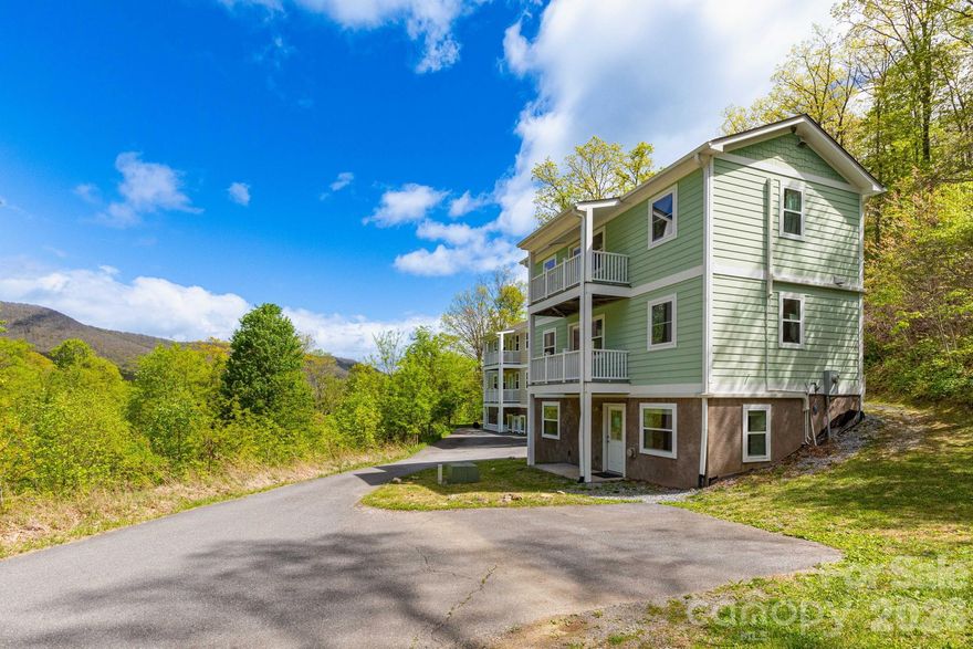 A versatile mountain retreat with built-in income potential awaits in the gated Mount Soma community. This distinctive three-level cottage is surrounded by serene natural beauty and offers mountain views along with flexible living arrangements ideal for full-time residence, vacation use, or rental income.

Designed to maximize privacy and functionality, each level features its own living space. The upper level includes a bright, open layout with a full kitchen, living and dining area, a private deck, and a bedroom with an ensuite bath—perfect for enjoying the peaceful setting. The main level offers a comfortable bonus room with ensuite bath, kitchenette, and its own living and dining area, plus access to a separate deck. The lower level provides a fully independent suite with exterior access, complete with a bedroom, full bath, and kitchen/living/dining space.

Currently part of Mount Soma’s short-term rental program, where each level is rented individually (buyer to verify), this property presents strong income-producing potential. Live in the upper levels while renting the lower, or continue the existing rental setup for maximum return.

Mini-split systems paired with propane wall heaters ensure year-round comfort. Residents of Mount Soma enjoy access to peaceful walking trails and tranquil community spaces, all within about 15 minutes of I-40 and about 30 minutes to Waynesville. This is a rare opportunity to own a flexible, income-generating mountain property in a truly peaceful setting.