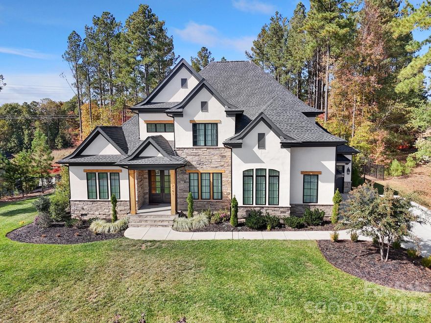 Custom built home located on a flat, interior lot within the gated Reflection Pointe community, offering privacy while still enjoying Lake Wylie access through a deeded boat slip. Backyard features a heated saltwater pool and spa with custom lighting, fenced yard, and covered and screened outdoor living spaces. Well designed open floorplan with high ceilings and quality finishes throughout. Kitchen features KitchenAid commercial grade appliances, gas cooktop, double ovens, oversized island, beverage and wine refrigeration, and a large walk-in pantry with prep space and room for small appliances. Primary suite on main level with gas fireplace. Bathroom and walk-in closet areas are fully connected and include a custom closet system that is easily reconfigurable to suit the next owner’s needs. Direct access to the laundry room from the primary suite. Three car side load garage with electric vehicle charging station. Ample storage throughout. Reflection Pointe amenities include gated entry, clubhouse, lagoon style pool, tennis and pickleball courts, walking trails, beach access on Lake Wylie, boat storage, and community docks. Convenient access to shopping, dining, airport, and major Charlotte area destinations. Boat slip #46