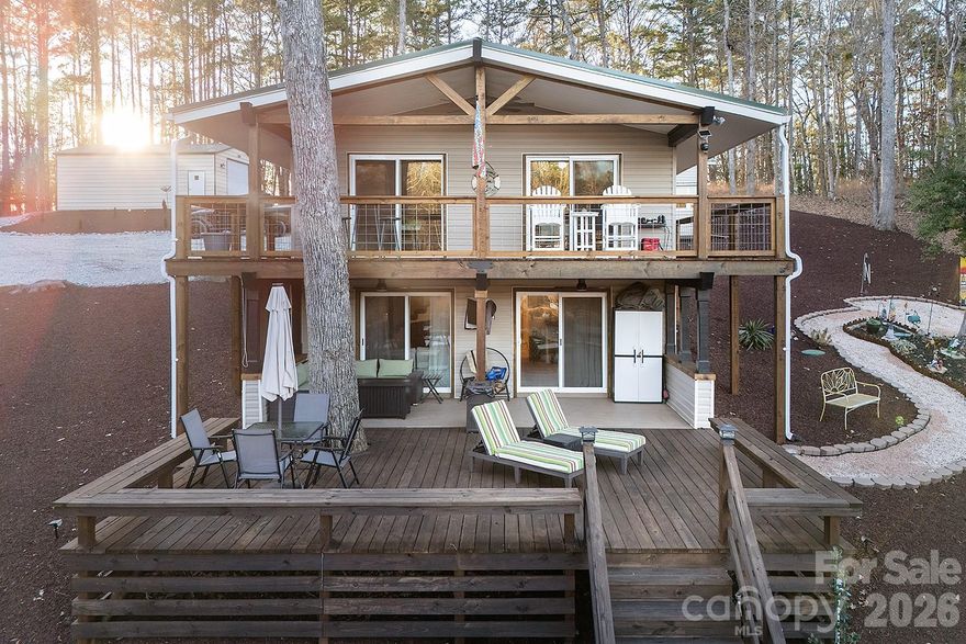 Elevated lake living with immediate income potential! Fully turnkey, short-term rental friendly, and ready to enjoy from day one! Exceptionally renovated and fully furnished lakefront residence on Lake Tillery, set on a ½-acre double lot with approximately 150 feet of pristine shoreline in a deep 12–14 ft cove. This thoughtfully designed home features 2 bedrooms, 2 updated baths, and a versatile bonus room with closet making it ideal for office, guest space, or additional sleeping area.

Extensive recent upgrades provide peace of mind and modern comfort, including a new metal roof (2025), updated electrical breaker box (2025), new front door and frame (2025), new sliding doors (2025), and all-new water lines from street to home and exterior spigots (2025). Both bathrooms were updated in 2024, and the kitchen was renovated in 2022 with Whirlpool appliances, all three years old or newer.

Outdoor living rivals the interior, featuring a new upper deck (2025), lower deck with stairs to the boathouse (2020), custom fire pit, and a serene zen hammock area overlooking the water! A 150-ft seawall with swell protection (2023) enhances shoreline durability and aesthetics.

The wired boathouse includes a pontoon lift and Seadoo drive-up pad, with buried electrical line installed in 2020. Additional structures include a 608 sq ft wired garage with roll-up door and a 346 sq ft wired shed with lean-to. Double driveway offers generous parking for all!

Offered completely furnished inside and out including kitchenware, TVs (including garage TV), linens, towels, and décor! Don't miss out on this amazing opportunity!