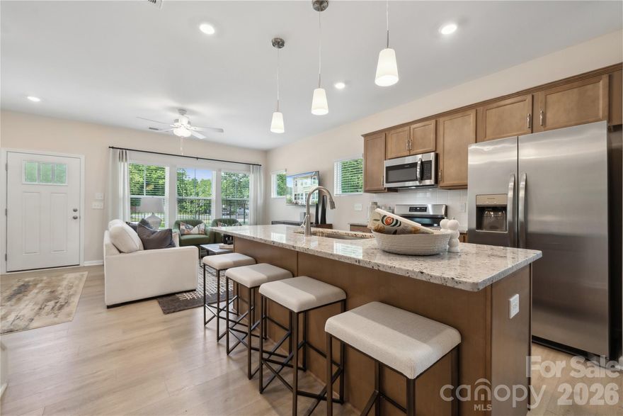 This thoughtfully designed two-story townhome offers three bedrooms and two-and-a-half bathrooms. Just inside the entrance, you'll find an open-concept great room that flows seamlessly into the kitchen and eat-in dining area. Upstairs, the primary suite includes a spacious walk-in closet, with a boxed ceiling and dual vanities for added luxury. Two additional bedrooms and a full bathroom are also located on the second floor, along with a conveniently placed laundry closet just outside the secondary bedrooms. A powder room is located just inside the entry from the attached one-car garage, with a built-in bench and cubby to keep essentials in check.