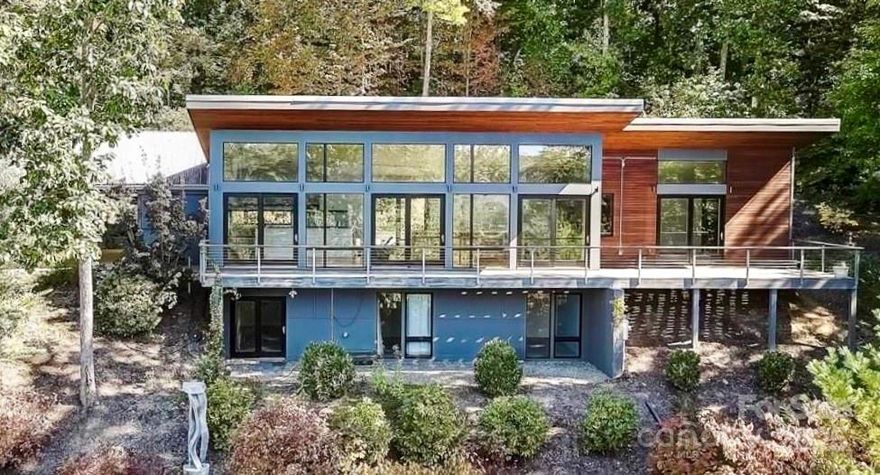 PANORAMIC MOUNTAIN & SUNSET VIEWS! Modern style abounds in this updated & remodeled stunner. Set on a secluded lane of 6 homes, this coveted Chunns Cove location is a very rare find - and only 6 minutes to Downtown Asheville! MAIN FLOOR LIVING open plan houses the owner's suite & 1/2 bath up, plus 2 bedrooms, 1 bed/bonus, & 1 full bath on the lower walk-out level. Your spacious kitchen features a Blue Star open-burner gas range (chef's dream!) & black stainless refrigerator. Incredible white oak floors, 6 sets of sliding doors, motorized ceiling-to-floor shades, & extensive landscape lighting add to the awesomeness. Outside, gather around your fire pit on the expansive deck overlooking the cove and beyond, relax in the luxury hot tub while watching the trees sway, or blaze a trail through your 1.65ac. Your driveway can even park a small RV! UNTOUCHED BY HELENE with uninterrupted utilities thanks to a Generac & updated well system. Move-in ready with most furnishings negotiable!