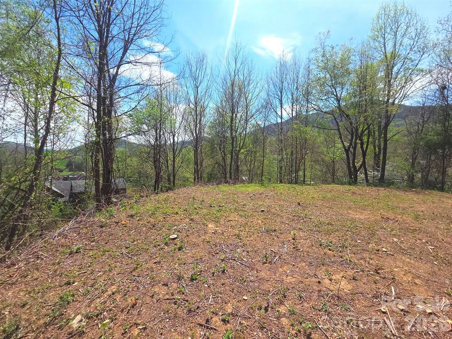 Near the breathtaking Great Smoky Mountains National Park, this rare 1.51-acre property offers an exceptional blend of accessibility, privacy, and stunning natural beauty. Imagine arriving home by crossing a charming covered bridge, with a ????? mountain setting and a picturesque river winding through the neighborhood. That truly sets this property apart is the ease of enjoying long-range mountain views—no steep climbs or challenging drive or access. A combination of paved and well-maintained gravel roads (including approximately 450 feet of level gravel on Turtle Rock Lane) makes reaching your future homesite simple and convenient. Located just outside city limits, you’ll benefit from no city taxes while still having access to city water (tap fee of $1,030 through the Town of Maggie Valley). The lot has been recently bush-hogged, making it easy to walk or drive onto the property and start envisioning your custom mountain retreat. Set within a small, cozy community of only 35 parcels, this property offers a sense of seclusion without sacrificing convenience. You’re just minutes from Waynesville, Maggie Valley, and the area’s many outdoor attractions, with easy access to Asheville, Cherokee, and Bryson City. Asheville Regional Airport is approximately 45 minutes away, making travel simple and accessible. Whether you’re planning a full-time residence or a mountain getaway, this property offers a rare opportunity to enjoy the best of the Smokies with comfort and ease.