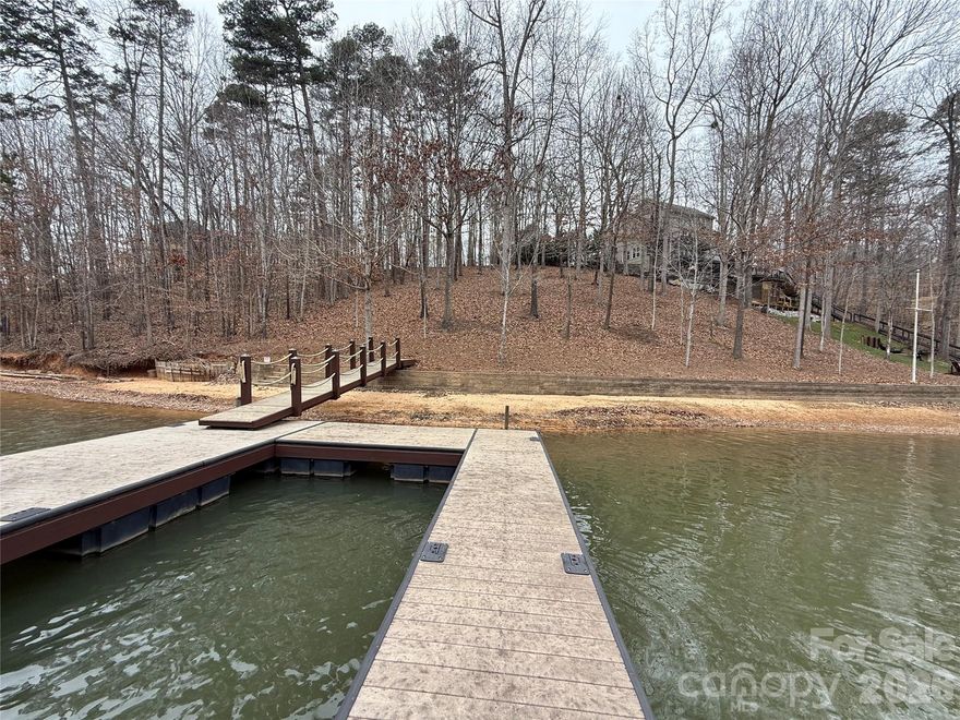 Rare opportunity to build your dream waterfront home in Harbour Watch, a private gated community known for its oversized lots, privacy, and peaceful setting. This .64-acre lot offers approximately 150 feet of shoreline on a wide, deep-water cove just off the main channel of Lake Norman—no dredging needed. A dock with Trex decking is already installed, a major value-add with current construction costs for similar docks starting around $60,000 in today’s market. A block seawall is also already in place, with comparable seawall installations currently ranging from $60,000–$80,000+, providing long-term shoreline protection and peace of mind.

The property is beautifully wooded with mature hardwoods and has been cleared of undergrowth, making it easy to walk, explore, and envision your future home site. A permanent 4-bedroom septic permit is already on file and will never require renewal. While Lake Norman is known for busy roads and waterways, this location offers a rare escape from traffic both on and off the water, delivering the quiet, relaxed lake lifestyle buyers are searching for. A truly exceptional homesite in one of Lake Norman’s most sought-after gated communities. (Photos were taken when Lake Norman was 4.4 feet below full pond. At normal levels water touches seawall)