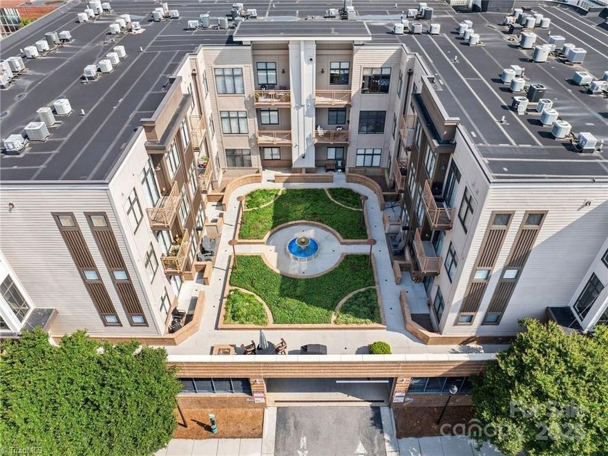 Nestled in the vibrant heart of downtown Winston-Salem, this beautifully appointed West End condo offers effortless city living just steps from dining, parks, and entertainment. Flooded with natural light, the 1BR/1BA residence boasts soaring ceilings, expansive windows, and sleek engineered wood flooring throughout the main living areas. Thoughtful design elevates everyday living with a spacious walk-in closet featuring custom shelving, a spa-like tiled walk-in shower, and a private patio overlooking a serene courtyard and a view of the city skyline from your bedroom. The kitchen, complete with a central island and bar seating, provides the perfect space for casual meals or lively gatherings. All appliances convey, including a refrigerator, washer, and dryer, ensuring a seamless move-in experience. With easy access to Truist Stadium, Atrium Health Wake Forest Baptist, and all the energy of downtown life, this rare offering blends style, convenience, and an unbeatable location.