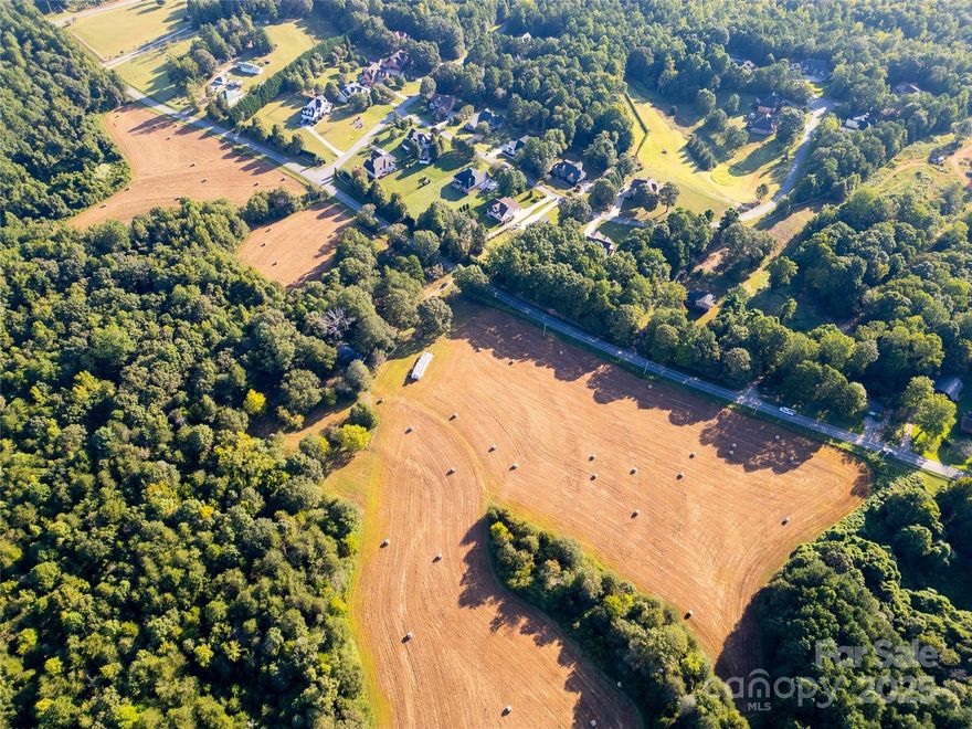 30+ acres in Lincoln County offering a rare combination of development potential and natural beauty. Zoned R-SF, the property allows subdivision into ¾-acre minimum lots, creating an excellent opportunity for spacious and private home sites. With approximately 2,780 feet of road frontage, access to the property is outstanding, offering both convenience and visibility for a variety of uses. The land is a mix of open fields and wooded areas, complemented by an old house and barn from the 1960s (sold “as is”). A well, septic, and electricity are on site but the functionality is unknown. A 15-foot fee-owned access area will be reserved to the rear acreage (138+/- acres), with the location negotiable. The adjoining land will be placed under a conservation easement, ensuring lasting privacy and a scenic buffer. An active cropped field lease is in place—crops at closing remain with farmer. Ideally located close to schools, dining, and shopping, just 35 miles to Uptown Charlotte, 28 miles to Charlotte Douglas International Airport, 10 miles to Downtown Denver, and minutes from Lake Norman. Perfect for a private estate with great building potential, family farm, equestrian property, agricultural/farming use, or residential subdivision development.