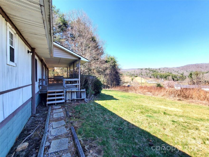 A Little slice of Paradise in the Appalachian Mountains of NC. Approx. 2.73 level/sloping acres with great views. There is an older mobile home on the property, a septic in place and spring water. Long Range Mountain Views from every step on the property with an elevation right at 3,000 feet. There is a 24x16 carport/canopy and a 8x10 storage building. The home needs work and is not on a permanent foundation.