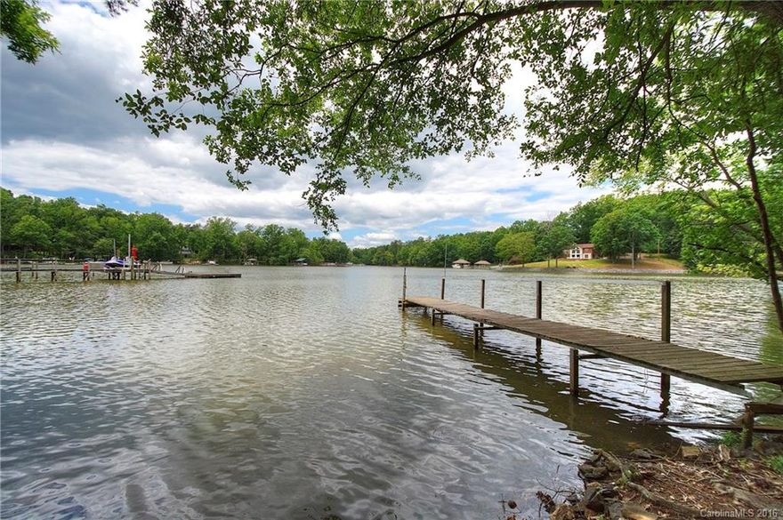 Waterfront cottage located in The Landing, but not part of the association!  You'll love the location, in the heart of Lake Wylie. 0.58 acre lot, overlooking wide channel on Mill Creek inlet, pier in place, 185' shoreline.  Cathedral ceilings w/ exposed pine beams for the quintessential lake home feel. Masonry fireplace, master bedroom on main level, spacious screened porch plus sunroom with hot tub. Envision the possibilities! Update to make this your lake getaway or permanent Lake Wylie home.