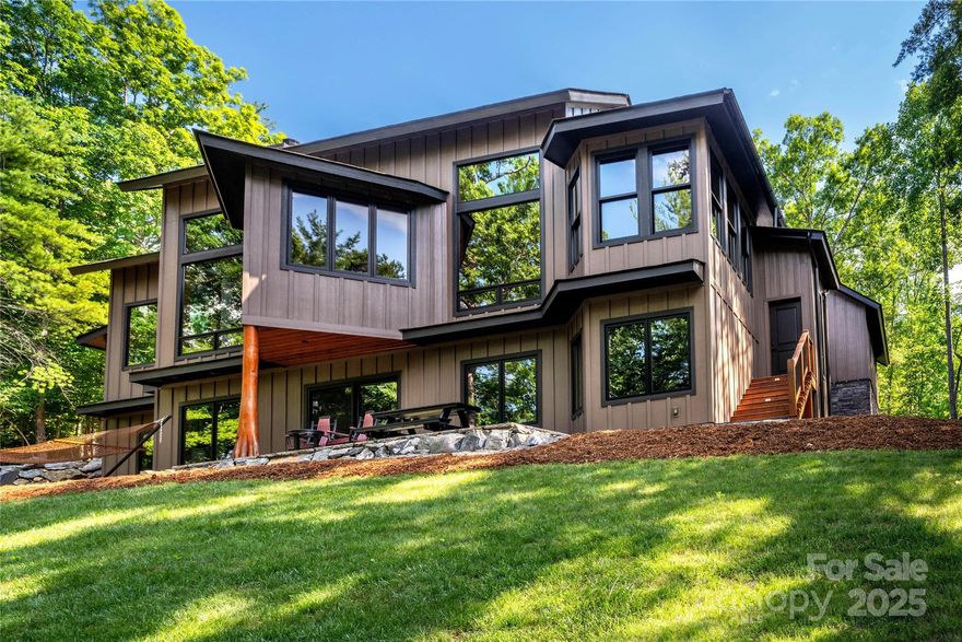 This magnificent waterfront home on Lake James, located in the beloved 1780 community, is now available with a price improvement. Designed by renowned architect Bruce Johnson, this meticulously crafted and lovingly maintained home offers breathtaking lake views from every window. A striking wall of windows welcomes you with shimmering water views, while the thoughtfully designed floor plan ensures nearly 100% usable space. The expansive living room, complete with a serene fireplace, flows seamlessly into a spacious kitchen, dining area, and sunroom overlooking the lake. The main-level primary suite provides comfort and privacy, while a well-equipped utility/mudroom leads to an oversized garage, offering more storage. The lower level, constructed with durable Monokast walls, features a second kitchen, a large family room, and three additional bedrooms-creating a fully self-sustaining living space and beautiful new flooring throughout.  Membership to Camp Lake James included!