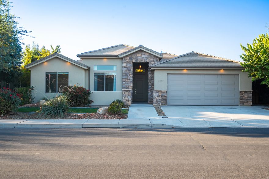 Beautiful single-level home in Santa Clara. This ideal location is walkable to restaurants, stores, & a park. Inside, this beautiful home features a gas fireplace, built-in entertainment center, plantation shutters, vaulted ceilings, 8-foot tall doors, cased windows, ceiling fans in all the bedrooms & great room, carpet, & new LVP flooring. In the kitchen, enjoy a gas range, stainless steel appliances, white cabinets, granite countertops, & a tile backsplash. The primary suite includes a large walk-in closet, & a separate tub, shower, water closet, & two vanities. Fridge, water softener, a one-year-old washer & dryer are included. Outside, you'll find a front courtyard, two covered back patios, & a fully fenced yard. Close to hiking, biking, Tuacahn Amphitheatre, & Snow Canyon State Park.