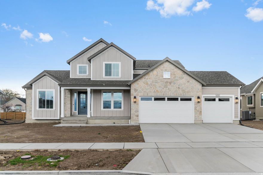 The Hamilton Traditional offers classic elegance paired with modern upgrades throughout. The kitchen features Bluff Maple cabinets enhanced with large crown molding and LED lighting, Quartz countertops, a striking full-height tile backsplash, and Stainless Steel Gas appliances with a double convection oven. The home showcases laminate hardwood flooring in main living areas, complemented by tile in wet spaces and comfortable carpet in bedrooms. A cozy Gas Log Fireplace anchors the Family Room, while French doors lead to the Living Room for added style and flexibility. The lower level includes 9-foot basement foundation walls and a convenient basement walk-up. Additional highlights include a 3-car garage with exit door, can lighting, Christmas light package, gas lines to the dryer and BBQ, and a radon ventilation system. Finishing touches such as tile surrounds in bathrooms, black matte hardware, textured walls, two-tone paint, and elegant Roosevelt base and casing complete this beautifully designed home.