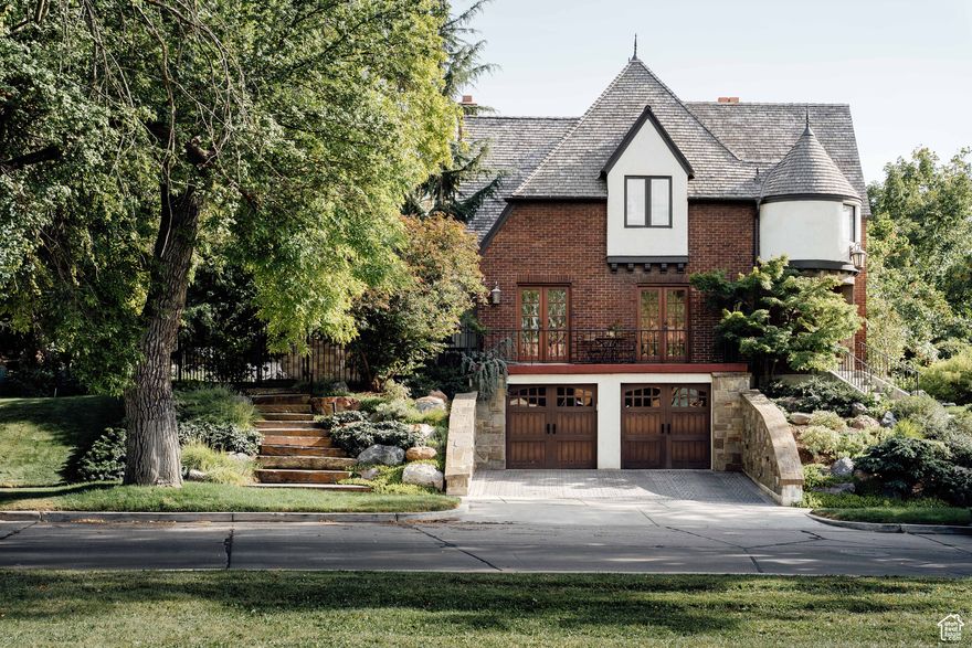 Presiding over the entrance to one of Salt Lake City's most idyllic neighborhoods, this four-bedroom, four-bath Yalecrest residence is a study in timeless elegance. Infused with French Revival influences-stained glass windows, garden doors, exposed beams, the graceful sweep of hardwood stairs, and a kitchen kissed with Parisian flair-every space feels intentional, intimate, and deeply romantic. Meticulous care has preserved its character, while thoughtful updates ensure modern comfort. The heart of the home is its fireplace. Made of earth-toned Batchelder tiles, it radiates warmth and durability. Yet it is the balcony that will steal your heart. Late afternoons overlooking crocuses in bloom, a glass in hand, are the simple pleasures we live for. Upstairs, the owner's suite invites retreat and reflection. Generous in scale, it features an en suite bath where a turreted shower evokes the whimsy of a European castle. There's a second bedroom and bath upstairs along with two more bedrooms and a bathroom in the lower level. Outside, English-inspired gardens create a serene, private oasis of roses and Japanese maples. A secret nook teases with daffodils, tulips, and wisteria. Hide-and-seek, anyone? And while this home is undeniably beautiful, it has also been thoughtfully enhanced, seamlessly blending historic allure with modern convenience. Every detail-from the materials to the finishes-speaks to living intentionally, a space for gathering, for dreaming, and savoring the sweet life.