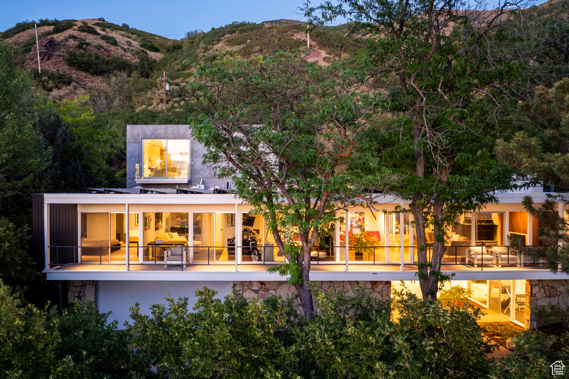 This home has always been a favorite-quiet from the street, almost secretive in its presence. But once invited in, its architectural story unfolds in brilliant layers. The proportions are impeccable throughout. The main approach is a gesture in symmetry and balance, anchored by a wide path that aligns precisely with the double entry doors. Above, the second story glows like a stretch of sunset horizon, with floor-to-ceiling windows that span the entire length of the home. A veranda cantilevers over stone walls. Inside, a five-foot-wide gallery hall extends from end toend, leading to a perfectly framed, north-facing glass wall that prompts moments of connection with the outdoor landscape. Originally designed by Jim Christopher, the home already embodied so many of the hallmarks of great design. Through a precise and reverent renovation, theoriginal home has been elevated to its highest potential. The property has been furthertransformed bySparano+Mooney, one of Salt Lake's most innovative architectural firms. Their modern addition in the back-affectionately known asThe Cube-sits in quiet conversation with the original structure. A brutalist form of glass and concrete, it exudes calm and composure, its presence both grounding and transcendent. Water reflects against its glass faade from the pool below, in whispering movements, like breathwork. Polished concrete floors join with an exposed concrete wall. Floating stairs rise beside a massive Poliform library wall. The scale and texture are breathtaking. The architectural lines extend to the pool, pool equipment pad, and garden area. Ahot tub, sheltered from the hillside by a concrete partition, sits just above the roofline to capture all the sunset and city views. From the herringbone floors and vintage hardware to the Italian cabinetry, every detail has been considered, crafted, and resolved. This home is a testament to design excellence in every aspect, from every angle, from the original to the new. Perfection is rare in architecture-but sometimes, through intention, vision, and collaboration, it sure comes close.