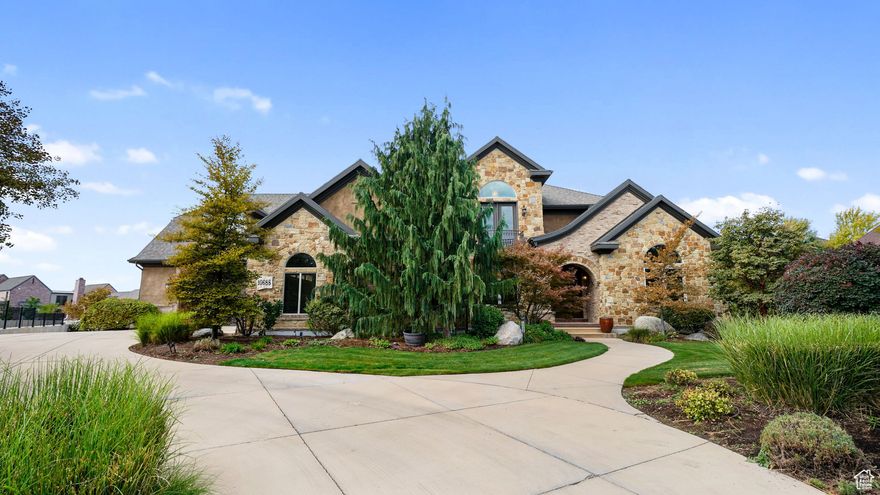 Welcome to Bison Ridge Estates, one of South Jordan's most prestigious neighborhoods, where timeless design meets modern comfort. This custom Tuscany-inspired 2-story estate sits on a rare 0.79-acre lot, offering privacy, luxury, and beautifully curated outdoor living. This home is more than a residence-it's a statement of craftsmanship, comfort, and elegance in one of South Jordan's most sought-after communities. The exterior boasts authentic stone, brick, and stucco with detailed soffit crowns, arched entry, and designer lighting. Step into manicured grounds with a custom timber pergola and fire pit retreat, a handcrafted swing, dry creek bed, and vibrant gardens-all framed by pre-cast fencing for both beauty and privacy. Multiple entertaining spaces include a covered patio, large deck, and walkout basement, creating a seamless indoor-outdoor flow. Inside, more than 8,200 square feet of refined living awaits. Soaring cathedral ceilings and rich finishes set the tone, featuring custom mahogany cabinetry, solid wood doors, built-in shelving, and 10" base moldings. The gourmet kitchen is a chef's dream with Thermador appliances, dual dishwashers, oversized island with detailed millwork, granite counters, and a striking range framed by ornate custom woodwork. The main-level primary suite offers a spa-like retreat, complete with dual stone vessel sinks, oversized walk-in shower with multiple sprays, a soaking tub under arched windows, and a custom-designed walk-in closet. Upstairs, you'll find a spacious family room overlooking the main level, additional bedrooms with private baths, and flexible spaces perfect for work or play. Though not fully finished, the basement is framed and drywalled for a large theater, second kitchen, expansive family area, three bedrooms, and two additional bathrooms-adding incredible potential and value. Every detail was built for efficiency and longevity, including 2x6 exterior framing, full spray foam insulation, dual geothermal heating and cooling, and an interior fire sprinkler system. The home also includes an extra-deep 4-car suspended garage with additional oversized 2-car garage below.