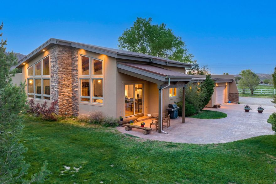 Custom Home on Five Acres with Expansive Moab Views and Guest Studio  Situated on five acres with beautiful Moab views, this well-built home welcomes you with a striking rock entryway and an impressive 8-foot alder front door. Inside, tall beamed ceilings reach approximately 16 to 18 feet at the peak, creating a spacious feel throughout the main living area. The living room offers a cozy gas fireplace and a comfortable space to gather while taking in the surrounding scenery.  The kitchen is designed for both everyday living and entertaining, featuring a propane KitchenAid 6-burner range with hood and oven, an additional wall oven, and an extra-large pantry with abundant storage. Sawmill flooring from Ashton, Idaho runs throughout the home, adding warmth and character. The laundry room includes a sink, washer and dryer, counter space, and cabinetry for convenience.  Each of the three bedrooms includes its own full bathroom. The primary suite offers a spacious retreat with a huge walk-in closet featuring built-in drawers and divided storage, along with a bathroom that includes double sinks, a stand-alone tile shower, a large jetted tub, and a separate toilet room.  The property includes 20 shares of Ken's Lake water, a septic system, and four water heaters that efficiently supply the main home, garage, laundry, and the workshop/ADU. The crawl space includes a heater, and the dryer is propane.  In addition to the attached two-car garage, the property includes a detached one-car garage with pass-through access and an attached two-car carport with both concrete and gravel surfaces.  A separate workshop building includes concrete floors with radiant in-floor heat and houses a studio-style ADU with stamped concrete floors, a kitchenette with sink, microwave, small stove, and refrigerator, and a bathroom with shower, sink, and toilet. The ADU does not have permanent cooling but can accommodate a window unit as needed.  Outside, the property features a fire pit area, garden space, and open space to enjoy the surrounding red rock views and peaceful setting. A neighboring parcel of 10 acres of land is available; details upon request.