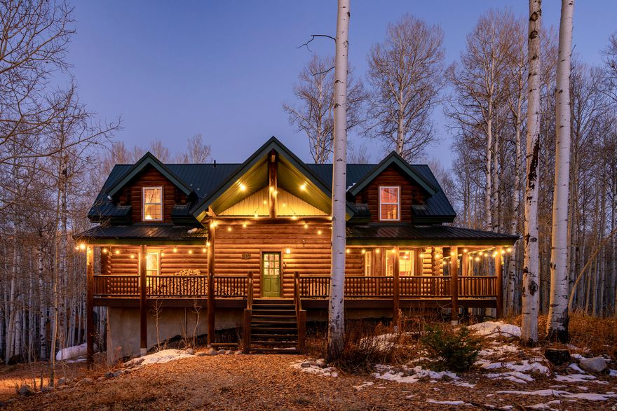 Nestled among a grove of aspens in the gated Timberlakes community, this charming log cabin embodies the best of mountain living with privacy, serenity, and timeless rustic appeal. Set back from the road with a circular drive and convenient access to an attached garage, the home feels both secluded and easily accessible. A sprawling wraparound porch invites you to relax and take in the tranquil setting, while the second deck offers additional outdoor space to dine, lounge, and enjoy the mountain air.Inside, the cabin's warm and inviting interiors showcase vaulted wood ceilings, mountain-inspired light fixtures, and a striking stone fireplace with a wood-burning stove offering the perfect gathering place after a day spent exploring nearby trails or skiing in Park City. Two main-level bedrooms open directly onto the deck, offering beautiful views and effortless indoor-outdoor living. Timberlakes provides residents with the peace and privacy of a mountain retreat while remaining just minutes from Heber City, Midway, Park City, and the recreation of the Wasatch Back.