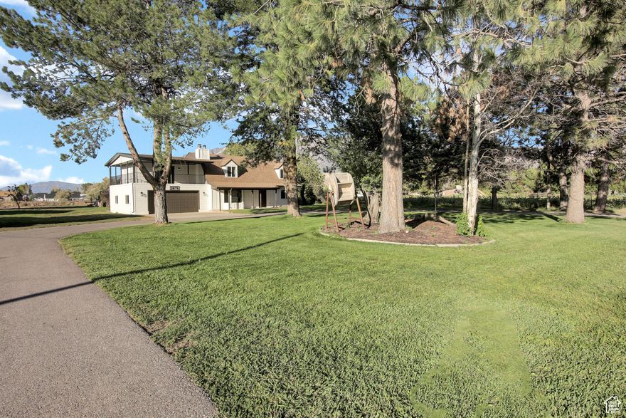 Don't miss your chance to own this stunning, one-of-a-kind modern farmhouse on just over an acre in Plain City. Set back from the street, this home sits beautifully in the center of the property, offering extra privacy and space to enjoy the peaceful surroundings. Inside, you'll find spacious bedrooms, a bonus office space, and a few fun surprises like a secret laundry chute and hidden garbage chute that add both charm and convenience. The home perfectly blends country comfort with a clean, modern feel and thoughtful design throughout. Updates include new electrical service (exterior meter base, panel, switches, and outlets), a brand-new central air system, and a recently installed septic system. Enjoy the outdoors with a custom fire-pit area, RV electrical hookup, and a covered patio ideal for taking in the sunset and mountain views. Upstairs, unwind on the private covered deck or take advantage of the open acreage-perfect for gardening, animals, or future projects. All this, just minutes from local amenities, schools, and recreation. With its modern updates, timeless character, and truly unique layout, this Plain City farmhouse is full of potential-with a little imagination, the possibilities are endless.