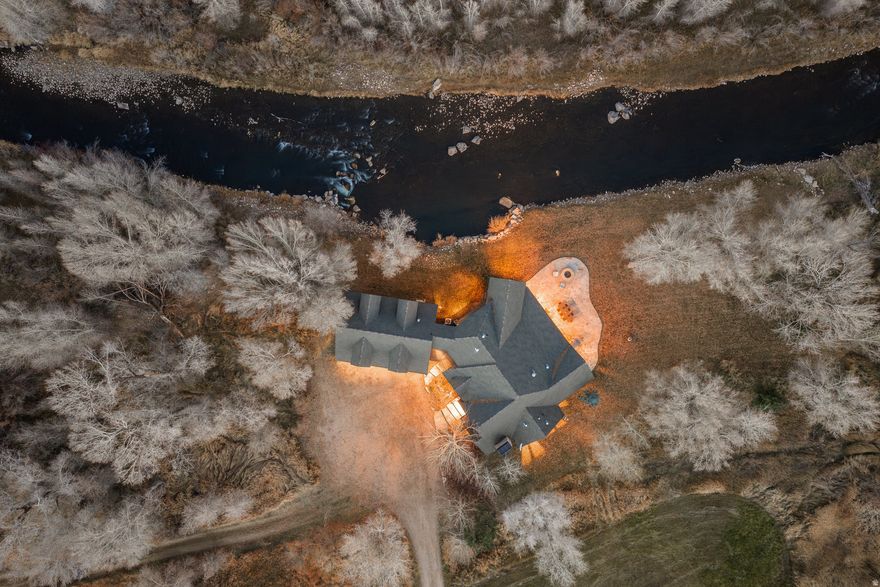 Wake each morning to the sound of the Weber River just outside your window, flowing only steps from the home in a setting that is no longer possible to recreate today. Situated on 12.44 private acres within the gated enclave of River Valley Ranch, this rare riverfront residence offers a lifestyle defined by water, open space, and year-round recreation. The home is built approximately ten feet from the riverbank under a grandfathered approval, allowing daily life to unfold alongside the river itself. Summer days are spent fly fishing from your own stretch of river, swimming in calm eddies, or relaxing on the lawn as the water moves past. Evenings bring fireside gatherings and quiet moments listening to the river as the sun sets across the valley. Recently refreshed with an updated kitchen, new lighting, and interior paint, the five-bedroom residence is both comfortable and inviting, serving as a peaceful retreat after time spent outdoors. Expansive lawn space and surrounding acreage provide room to gather, recreate, and enjoy the openness of the land, while year-round access ensures ease of use in every season. In the winter, world-class skiing at Deer Valley's East Village and Park City is just a short drive away, offering a rare balance between alpine adventure and riverfront living. A protected conservancy bordering the east side of the river preserves views and privacy across the water, ensuring lasting tranquility. The property also offers the opportunity to purchase adjacent acreage, allowing a future owner to expand their footprint and create a larger legacy estate. Located minutes from Heber City, Park City, and Deer Valley, this riverfront residence presents an exceptional opportunity to live immersed in nature without sacrificing proximity to premier mountain amenities.