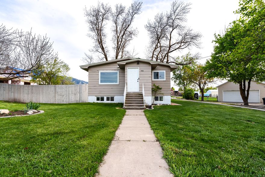 Tucked into a quiet, tree-lined neighborhood in North Logan, this fully updated home sits on a spacious .33 acre lot with room to live, grow, and enjoy the outdoors. Thoughtfully renovated throughout, you will find fresh paint, new flooring, a completely updated kitchen, upgraded electrical and plumbing, a new tankless water heater, new water softener, and new upstairs windows, giving you peace of mind and modern comfort from day one. Step outside and the property really shines. Enjoy garden beds ready for your personal touch, an oversized detached garage with plenty of room for projects or storage, a charming chicken coop, a playset, and a cozy firepit, perfect for gathering with friends and family. The included 1/2 water share adds extra value and flexibility for maintaining the outdoor space. Located within walking distance to Elk Ridge Park, this home offers a rare blend of privacy, space, and convenience in one of North Logan's most desirable settings.  Home is virtually staged.