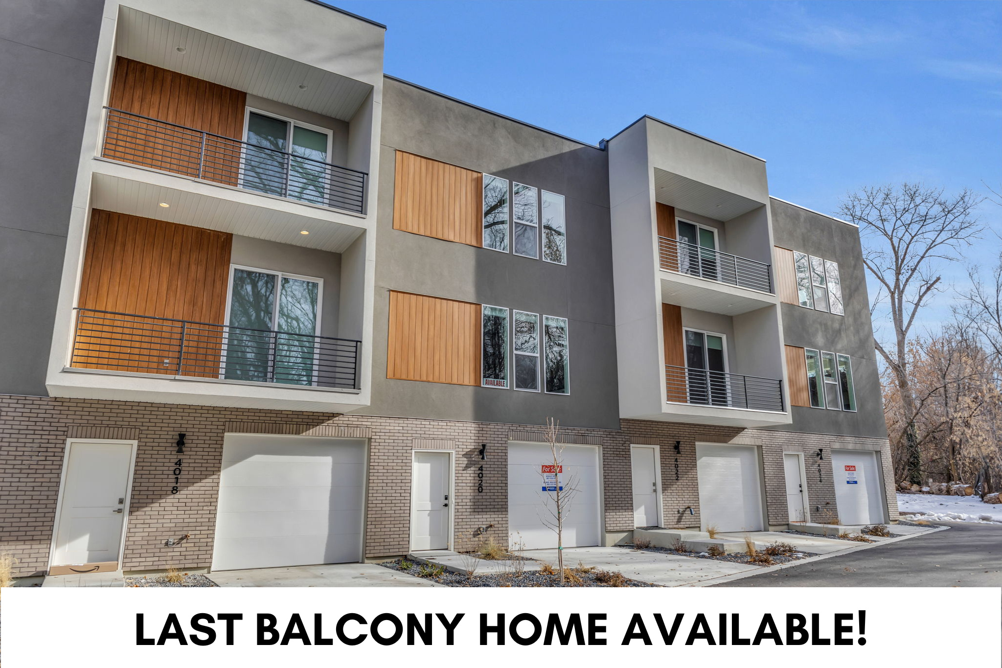 Modern multi-story facade featuring textured gray and light-colored stucco, brick accents, and wood-finish paneling