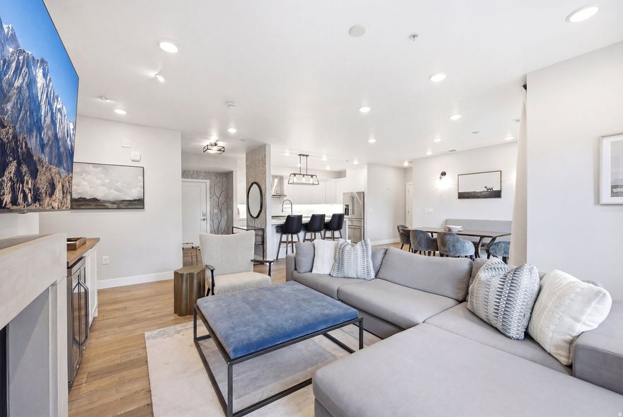 Top-floor luxury living awaits at The Station, Holladay's premier condominium community in the heart of Holladay Village. This beautiful fully furnished residence offers 2 bedrooms, 2 bathrooms, and approximately 1,400 square feet of sophisticated, low-maintenance living with stylish finishes and a thoughtfully designed open layout. A rare and highly sought-after feature is the two dedicated parking stalls in the secure, climate-controlled garage with controlled access, providing exceptional convenience, comfort, and peace of mind year-round. The spacious floor plan is filled with natural light and features an inviting living area centered around a cozy gas fireplace. The kitchen is elegantly appointed with quartz countertops, beautiful cabinetry, and a striking waterfall island-perfect for both everyday living and entertaining. Two private bedroom suites are positioned on opposite sides of the home, creating ideal separation and privacy. The primary suite offers a walk-in closet, spacious walk-in shower, and direct access to a private balcony, which is also accessible from the main living area-an ideal setting to enjoy peaceful mornings or relaxing evenings. Elevator access and step-free entry add to the effortless lifestyle this community provides. Residents also enjoy exceptional amenities, including an expansive rooftop terrace with fire pits, gathering spaces, and sweeping views of Mt. Olympus and the Salt Lake Valley. The pet-friendly community also features a convenient dog-washing station. Step outside your door and enjoy the walkable lifestyle of Holladay Village, where dining, shopping, grocery stores, parks, spas, food trucks, and live music are just moments away. For outdoor enthusiasts, nearby canyons offer year-round recreation, from hiking and biking to world-class skiing.