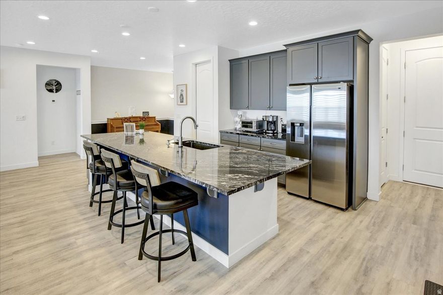 SINGLE LEVEL LIVING! South-facing rambler, located in the Jackson community in beautiful Herriman. Minutes from Mountain View Corridor, TRAX lines, and the new Salt Lake Bees Baseball Stadium. The main level has soaring 10-foot ceilings, creating an open, spacious feel, while the basement has 9-foot ceilings, making every part of this home feel expansive. The kitchen boasts a massive 12-foot island with bar seating, double ovens, a gas range, stainless steel appliances, granite countertops, and sleek LVP flooring that flows throughout the upper level. Beautiful plantation shutters throughout for a clean and timeless look. Primary bedroom with an ensuite bathroom featuring double sinks, granite countertops, a separate tub and shower, and a WIC. The spacious, unfinished basement provides endless possibilities and features a built-in radon mitigation system, a tankless water heater, and a water softener. Step outside to a fully fenced backyard, perfect for privacy and pets, along with a covered patio. This home is move-in ready and designed for comfort, style, and practicality. Square footage figures are provided as a courtesy estimate only and were obtained from county records. Buyer and Buyer's agent to verify all information. A pre-approval letter from the lender or POF must accompany all offers.  **Seller has requested no showings on Tuesdays and Thursdays. Please schedule 24 hours prior to showing.**