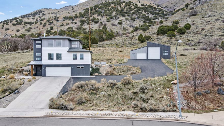Stunning Mountain Modern Home on Logan's East Bench with Expansive Shop & Unmatched Views. Experience the best of Cache Valley living in this unique mountain modern home, perfectly situated on a private east bench lot backing the Bonneville Shoreline Trail. Enjoy breathtaking 360-degree views of the surrounding mountains and valley from nearly every angle. Step inside to a bright, welcoming open floor plan featuring vaulted ceilings, custom lighting, and upscale finishes throughout. The thoughtfully designed kitchen showcases quartz and butcher block countertops, blending style and functionality for everyday living and entertaining. The main level offers two bedrooms, a full bathroom, and convenient main-floor laundry. Upstairs, the entire second level is dedicated to a private owner's retreat-complete with a loft-style suite, panoramic views from every window, and a luxurious en-suite featuring a walk-in closet with its own laundry. This exceptional property also includes a massive shop, ideal for hobbies, storage, or workspace needs. Outside, enjoy a low-maintenance yard designed for privacy, complete with unobstructed views and a relaxing hot tub setting. Square footage figures are provided as a courtesy estimate only and were obtained from county records. Buyer is advised to obtain an independent measurement.