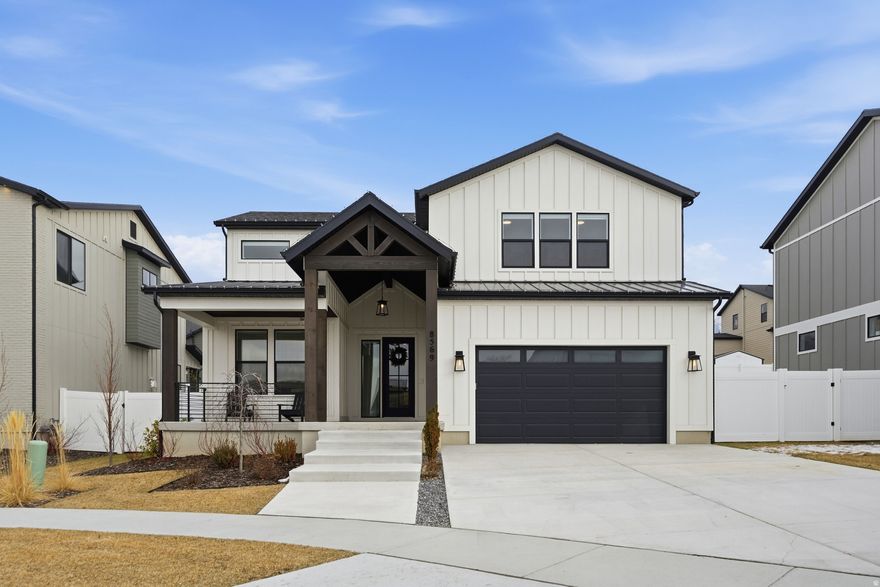 Welcome to 8569 Round Stone Cove , a 2024-built contemporary retreat in the heart of Sandy, minutes from World Class Ski destinations.  Tucked into a quiet cul-de-sac, this light-filled, thoughtfully designed home offers the perfect blend of clean modern style and functional living. From the moment you step inside, you'll appreciate the bright, open layout, soaring ceilings, and expansive windows that flood the home with natural light.  The main floor features a spacious primary suite for true single-level living, complete with a beautifully appointed bath and generous closet space. The open-concept great room centers around a sleek fireplace and flows seamlessly into the designer kitchen-showcasing white cabinetry, quartz countertops, stainless steel appliances, a large island with seating, and contemporary finishes throughout.  Upstairs and down, the layout offers flexibility for family living, guests, or entertaining. The fully finished basement provides additional living space perfect for a media room, playroom, home gym, or guest quarters.  Clean lines, modern railings, warm-toned flooring, and neutral finishes create a timeless aesthetic that feels both elevated and inviting. The exterior features fresh modern curb appeal, a covered front porch, and a spacious driveway with attached garage.  Located in a desirable Sandy neighborhood with convenient access to parks, shopping, dining, and the Wasatch Mountains, this nearly new home delivers style, comfort, and move-in-ready ease.  Why wait to build when you can move right in?