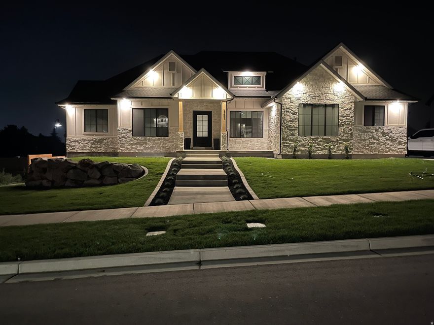 This extraordinary modern craftsman masterpiece w/ lake views is designed to impress from the moment you step through the custom steel front door. Showcasing soaring 14' ceilings, oversized spaces, & impeccable high-end finishes throughout, every detail of this home was thoughtfully crafted to deliver both luxury & functionality. From the stunning 6" plank hardwood flooring to the expansive office, oversized mudroom, massive main-floor laundry room, & incredible butler's pantry complete w/ a convenient Costco door, this home offers elevated living at every turn. At the heart of the home, the chef's kitchen is a true showpiece featuring crisp white quartz countertops, a farmhouse sink, tiled backsplash, premium gas cooktop, and abundant cabinetry, all seamlessly connected to the open-concept living space. The striking linear gas fireplace set against a dramatic rock accent wall, custom built-ins, & elegant tray ceiling create a warm yet sophisticated atmosphere perfect for entertaining or everyday living. Large-format windows flood the home with natural light, while 8' doors & upgraded 6cm countertops throughout further enhance the custom luxury feel. The spacious primary suite is a private retreat designed for comfort & relaxation, offering a spa-inspired bathroom complete w/ a dual vanity, a freestanding soaking tub, oversized double-head shower, & an expansive walk-in closet. Every bedroom throughout the home is generously sized, providing exceptional space for family & guests alike. The fully finished walkout basement is equally impressive, accessed by an extra-wide 4' staircase & featuring 9' ceilings, daylight windows, a full 2nd kitchen, additional laundry room, 2 beautifully finished bathrooms, 3 additional oversized bedrooms, abundant storage space, & direct access to the backyard through sliding glass doors-making it ideal for multi-generational living, entertaining, or a potential mother-in-law setup. Step outside to your own private backyard retreat featuring a generator so you never lose power, a large two-tier covered deck, fire-pit area, basketball court, playhouse, trampoline, a charming chicken coop and it even has Solar Panels for virtually no electric bill . This one-of-a-kind property perfectly blends luxury, comfort, & lifestyle in a way that is rarely found. A truly spectacular home you will not want to miss.