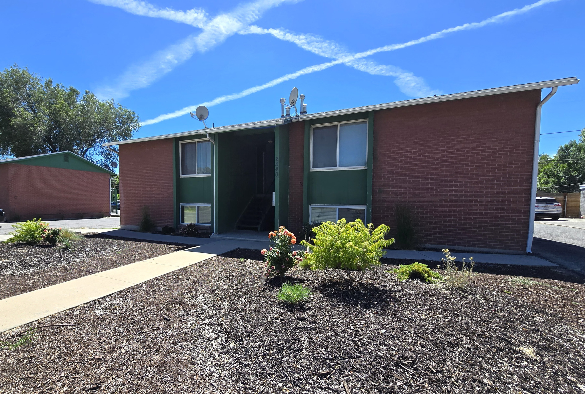 Brick exterior building with green facade accents
