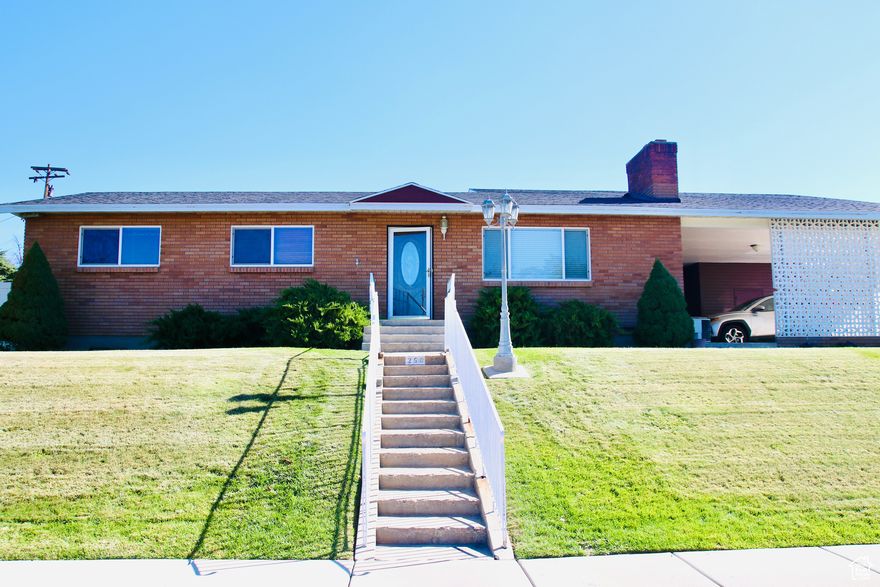 Enjoy spacious living areas featuring hardwood floors, a cozy wood stove & gas fireplace. Formal dining room complete with seating for 10 table & a china cabinet. The kitchen includes a fridge, updated dishwasher, and microwave. Practical upgrades include a new roof (2024), updated windows, water softener, furnace (2011), & water heater (2008). Outdoor living shines with a covered patio equipped w/power & lighting, garden boxes with irrigation, a shed & mature peach & cherry trees. Ample parking & storage options include a two-car garage w/attic storage above plus dedicated circuit, covered RV parking, & a two-car carport. Perfect blend of comfort, function, and character.