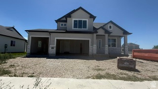 Two-story residence featuring light gray stucco siding and dark roofline accents