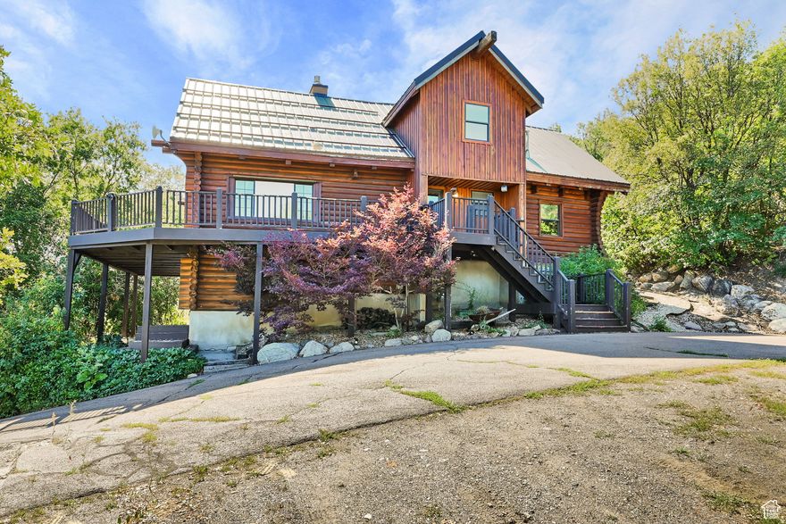 This unique and rustic home is the perfect opportunity to own your own mountain retreat in the Ogden Valley! This log home sits on a 1-acre lot and features panoramic views of the Wasatch Mountains and valley floor. It also has a direct view of James Peak, home of Powder Mountain ski resort. The large wrap-around front porch is a perfect place to enjoy the views and take in the outdoors. Step inside and find a main level that offers a spacious living area with high ceilings, and a kitchen with built in wine fridge and plenty of cabinets for storage. You'll also find 2 bedrooms and a full bathroom. The primary suite on the upper floor features a walk in closet and a large primary bathroom, and a balcony. The lower level features an additional living room, a mudroom area with storage, two additional bedrooms, another full bathroom, and an additional storage area. The property is located less than a mile from Nordic Valley Ski Resort, 20-minutes from Powder Mountain, and 25-minutes from Snowbasin.