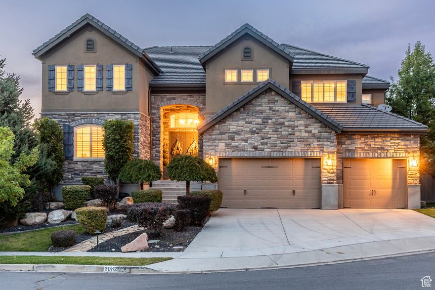 Tucked away in one of Lehi's most desirable neighborhoods, this exceptional residence is one of only four homes in a private cul-de-sac, offering sweeping mountain and valley views along the Traverse Mountain bench. From the moment you step inside, you're welcomed by the warmth of rich Walnut hardwood floors and a soaring double-height foyer that sets the stage for the home's blend of luxury and comfort. The open-concept living space flows seamlessly into a gourmet kitchen featuring Viking stainless steel appliances, double wall ovens, and an oversized granite island with striking iron accents. A custom wood, iron, and frosted-glass barn door conceals the pantry, merging style with function. Downstairs, the home transforms into a true entertainer's retreat. A full second kitchen-also equipped with Viking appliances-anchors the space, complemented by a guest suite, full bath, glass-enclosed steam shower, home gym, and a tiered theater room designed for unforgettable movie nights. Walkout French doors lead to an outdoor sanctuary with a natural stone patio, hot tub, trellis-covered deck, and a fully equipped outdoor kitchen with granite-topped BBQ station-perfect for hosting under the stars. The upper level is devoted to rest and rejuvenation. The primary suite offers a dual-sided fireplace, expansive "his & hers" walk-in closets, and a spa-inspired bathroom with dual vanities, soaking tub, glass shower, and private water closet. A spacious three-car garage completes the property, providing plenty of room for vehicles and outdoor gear. This rare offering combines elegance, comfort, and convenience-all within minutes of Silicon Slopes, shopping, dining, and outdoor recreation.