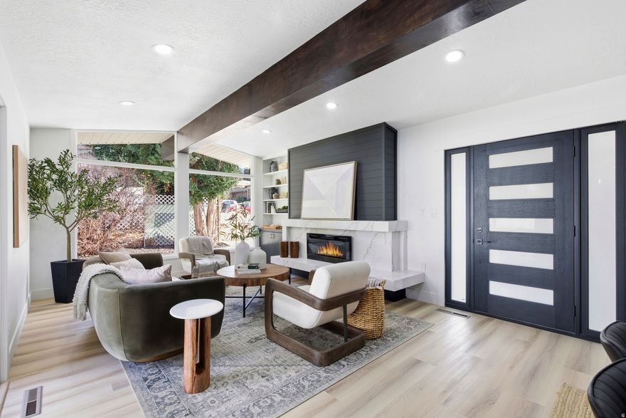 Welcome to this beautifully updated home in the heart of Holladay, one of the most desirable and established areas on the east side. Perfectly positioned near top-rated schools, this location is what so many buyers wait for. Inside, the home opens up with soaring vaulted ceilings in the main living area, creating an airy, open feel from the moment you walk in. A stunning floor-to-ceiling fireplace with quartz stone accents anchors the space and brings a warm, designer touch. The kitchen features a sleek waterfall-edge peninsula and thoughtful selections that make the entire space feel elevated and cohesive. With 6 bedrooms and 3 bathrooms, the layout works effortlessly for anyone needing space, flexibility, or multi-generational living. The primary suite includes a high-end tiled shower with a rainfall shower head and LED mirrors. Accent walls, designer lighting, and an intentional color palette throughout the home add personality without overpowering the calm, modern feel. Downstairs, a spacious family room with a stylish wet bar creates the perfect setup for entertaining, movie nights, or hosting guests. If you've been searching for a home with standout design in one of Holladay's most coveted neighborhoods, this is it.