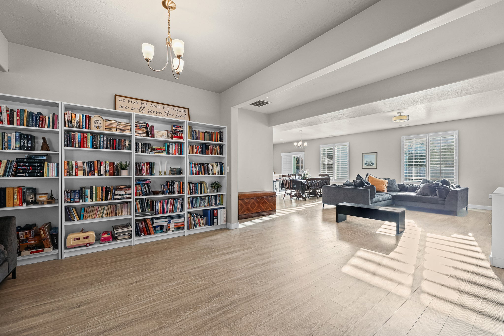 Spacious open-concept interior featuring light wood-finish flooring, built-in shelving, and recessed lighting