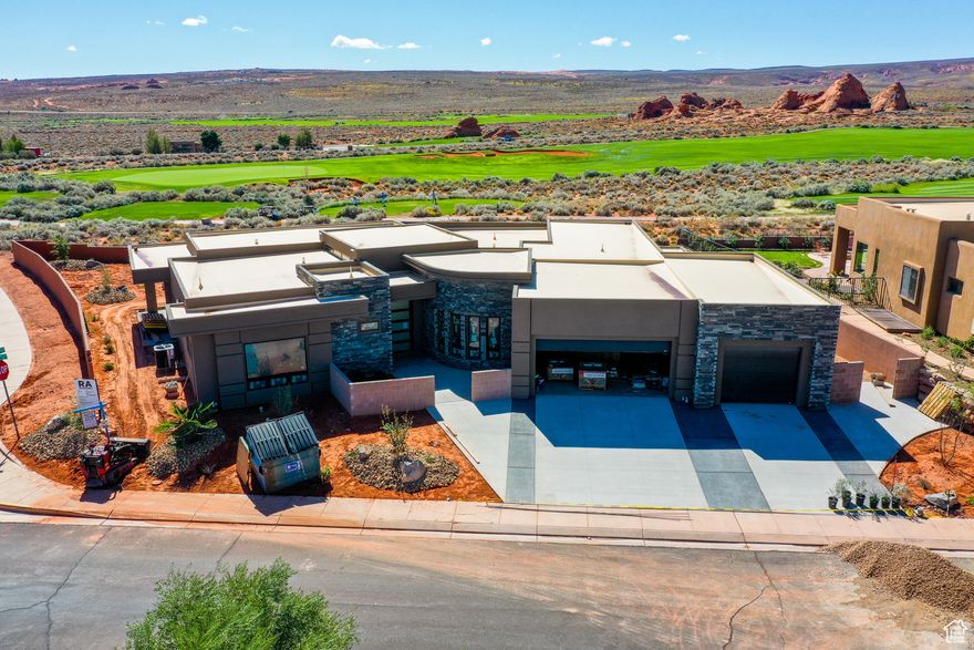 Discover unparalleled luxury in this 5-bedroom, 5-bathroom, 4,215 SF custom home, perfectly nestled between the 9th green and 10th fairway of the world-renowned Sand Hollow Golf Course. Designed by Allen Key Development, this .35-acre sanctuary captures breathtaking golf course and mountain views, blending elegance, innovation, and comfort.  Step into a grand entry with a striking 5' x 9' pivot glass door, leading to a designer kitchen featuring Thermador appliances, two wall ovens (one with Home Connect smart technology), a Zephyr vent hood, soft-close cabinetry, and a glass-door beverage cooler. The hidden pantry and prep area elevate functionality, while the private ADU, complete with a mini kitchen, washer/dryer hookups, and separate HVAC-offers versatile living options.  Indulge in spa-inspired bathrooms, with the primary suite boasting a sauna, quartz transparent shelf with integrated lighting, and an elegant makeup bench. Two fireplaces, an electric one in the primary bedroom and a gas fireplace in the great room, create a cozy ambiance. Zoned HVAC with dual units ensures tailored comfort, while Anderson windows, 2x6 framing, R49 insulation, and sound-dampening walls prioritize energy efficiency and tranquility.  Outside, the pool-ready backyard with gas stub for a BBQ, fully fenced yard with sleek metal railing, and a finished courtyard with built-in seating invite seamless outdoor living. The extra-wide 3-car garage includes a 37' deep tandem bay-ideal for dual vehicle storage, gear, or workspace. The premium epoxy flooring offers long-term durability, low maintenance, and a polished look that elevates the space, while the solid Martin doors add architectural elegance and enduring quality.  With dual 220V EV charging outlets, this space is not only refined, it's future-ready.   Fiber internet-ready conduit ensures modern connectivity. Located minutes from Sand Hollow Reservoir for water sports and thousands of miles of off-roading trails, this home is an adventurer's paradise. Ranked among Golf World's Top 100 Courses, Sand Hollow's dramatic red-rock cliffs and vibrant greens create a stunning backdrop. Enjoy a transferable builder's warranty and a personalized orientation upon sale for ultimate peace of mind. This is more than a home-it's a lifestyle of luxury and adventure.  POOL IN 3D MODEL/VIDEO IS NOT INCLUDED