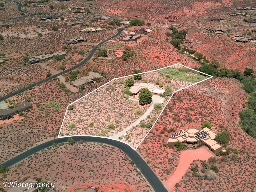 Welcome to Shonto Ridge, an extraordinary 3.7-acre estate perched high above the Kayenta Wash, where uninterrupted 360-degree views capture breathtaking sun and moonrises, radiant sunsets igniting the Kayenta Cliffs, and dazzling seasonal firework displays against the desert sky. It is, quite simply, a magical setting. A private driveway ascends to the residence, quietly positioned atop the ridge to maximize both seclusion and scenery. Walls of fixed picture windows frame sweeping vistas from nearly every vantage point, seamlessly blending indoor living with the surrounding red rock landscape. Thoughtful updates enhance the home's enduring character, including solid-wood flooring, solid-wood interior doors, updated kitchen appliances, a newer heat pump and water heater, whole-house air purifiers, and refreshed exterior stucco. The interiors offer an effortless flow, anchored by a spacious great room and dining area designed for gathering. A beautiful office or guest suite provides flexibility, while a private suite with its own separate entrance offers ideal accommodations for guests or multi-generational living. The property may be enjoyed as a turnkey retreat or expanded with creative vision. A rare opportunity to further elevate an already remarkable estate. Outdoors, mature trees and manicured walkways guide you to private access into the scenic Kayenta Wash, where abundant birdlife and tranquil desert surroundings create a true sanctuary experience. Optional access to the Kayenta community pool further enhances the lifestyle offerings of this exceptional property. Blending privacy, panoramic beauty, and refined comfort, Shonto Ridge presents a rare opportunity to own one of Kayenta's most captivating view homes.