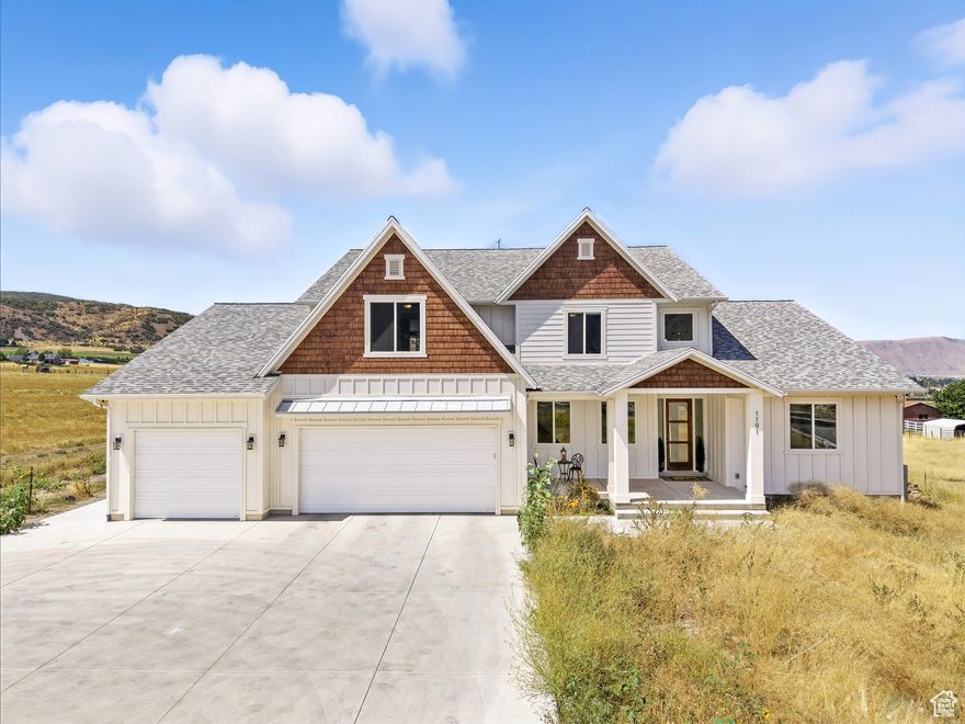 Be sure to click "Tour" for a 3d home walk through!  From the moment you arrive, this home greets you with quiet privacy, set 150 feet back from the road, where peaceful surroundings and expansive mountain, valley, and lake views stretch out in every direction. Step through the wide entry and into soaring 19-foot ceilings in the living room, where walls of windows flood the space with natural light and frame sunsets that will take your breath away.  The open floor plan connects everything together-the kitchen, dining, and living area flow seamlessly so you're always part of the conversation. At the heart of it all is the largest quartz island possible from a single slab-over ten feet long and five feet wide-designed for gathering, cooking, and creating memories. The island houses your Bosch induction cooktop and a Zephyr motorized downdraft for the stove that disappears seamlessly into the counter when not in use. Surrounding it, high-end Bosch convection ovens with side-opening doors, a microwave in the kitchen and another in the pantry, and two stainless steel KitchenAid dishwashers that actually clean your dishes make every meal effortless. Custom Italian TSV cabinetry, a massive walk-through pantry with extensive custom shelving, and space for two fridges, a chest freezer, and even a direct garage entry for bringing in groceries with ease mean the kitchen is as functional as it is stunning.  On the main level, your 17' x 39' owner's suite is more than a retreat-it's a sanctuary. With its own sitting area, oversized shower, soaking tub, and attached 17' x 13' office, your days begin and end with comfort and sweeping views of the entire valley, Utah Lake, and the mountains-scenes that few ever get to call their own.  Upstairs, your 850-square-foot loft overlooks the family room below and opens to a second-level covered deck with ceiling fans-the perfect perch to take in the valley views.  Every detail is designed for living well. Extra-wide stairs designed for comfort, flow, and ease of living, smart blinds that respond to Alexa or Google, energy-efficient LED lighting, and a whole-house fan that cuts cooling costs by up to 90%. The laundry room takes convenience further with custom cabinetry, quartz countertops, laundry basket stations, and raised bases for the washer and dryer.  Step outside to to the covered front porch, or gather on your expansive covered back patio with ceiling fans and space for grilling and dining. From there, stairs lead down to your private 90' x 90' grass field-big enough for soccer games (complete with an outdoor drinking fountain), reunions with friends, watching an outdoor movie, or simply enjoying the sunset by a fire with your loved ones.  With a separate two-bedroom apartment complete with its own full kitchen and laundry-perfect for multigenerational living or income potential, massive parking, a mudroom designed for everyday life, 400-amp electrical service and 2 lb. gas service provide ample capacity for you to add a pool, spa, gas-heated workshop, additional HVAC, and any upgrade you envision, and one of the quietest, most serene settings in the county, your home is more than a place to live-it's where life expands. (Please note that 2 of the 5 bedrooms, and a full bathroom are in the accessory apartment which is not pictured on the 3d Tour)