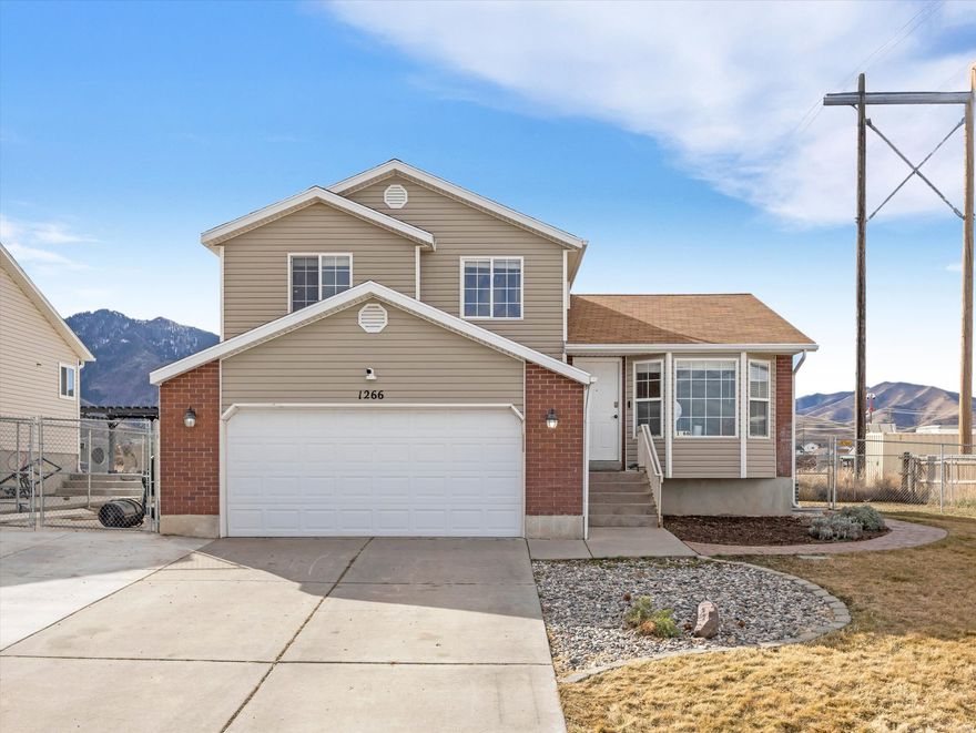 * Receive up to $4,000 in closing cost assistance, ask us how.*  Welcome to 1266 E 850 N in Tooele, where comfort, flexibility, and everyday ease come together in a home designed for real life.  With 4 bedrooms, 2.5 baths, and 1,951 sq ft, this home offers space to spread out while still feeling warm and connected. Natural light pours through the bay window in the dining area, creating a bright spot for morning coffee, weeknight dinners, or quiet moments looking out toward the mountains.  The kitchen opens into the dining space and offers a functional layout with peninsula seating, making it easy to cook, gather, and stay connected. Downstairs, the cozy family room creates a natural retreat for relaxing evenings, movie nights, or simply unwinding at the end of the day.  Upstairs and down, the four bedrooms offer flexibility for a variety of needs such as work-from-home space, hobbies, guests, or quiet retreats.   Outside, the fully fenced yard provides room to enjoy fresh air, entertain, or simply relax. RV parking adds extra convenience and versatility.  This home offers a comfortable setting to create your next chapter in Tooele.  Square footage figures are provided as a courtesy estimate only. Buyer is advised to obtain an independent measurement.