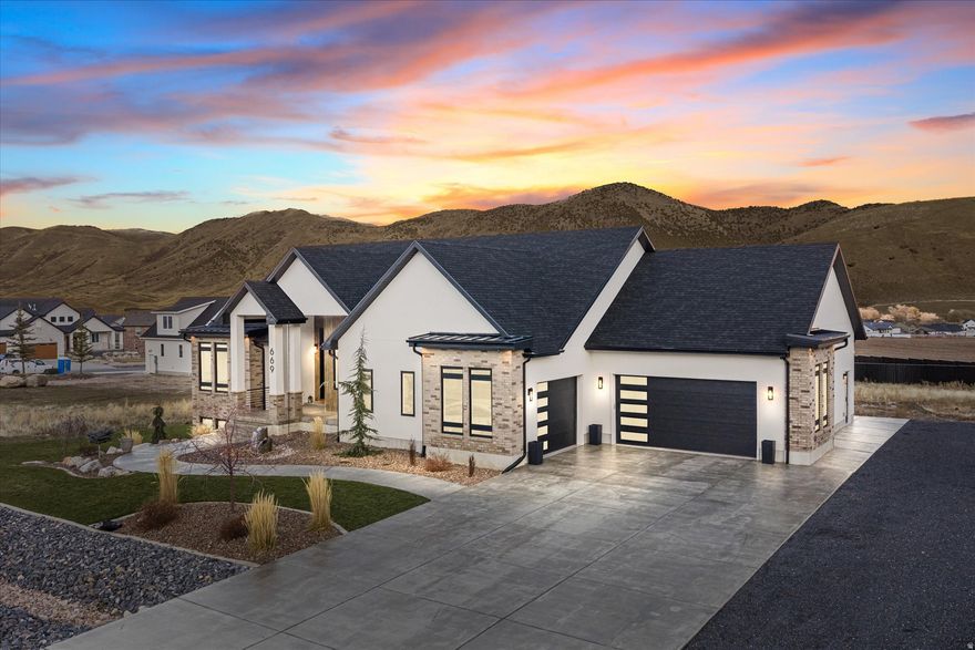 This beautiful custom build is perfectly situated in the idyllic town of Mantua, offering breathtaking mountain views, small-town charm, and easy access to outdoor recreation.  Step inside to find spacious open-concept living with high-end finishes throughout. The main level features a gourmet kitchen with custom cabinetry, quartz and honed black granite countertops, commercial fridge and freezer, a top of the line gas range, and a large island-perfect for entertaining. The attached butlers pantry boasts extra storage and prep space, along with double wall ovens.   The adjoining great room features 12 ft ceilings, engineered hardwood floors, and a cozy fireplace, creating the perfect gathering space. Large black Andersen casement windows let in natural light and gorgeous mountain views. Walk through the sliding doors to the oversize deck to take the views in more fully. Home is equipped with a full audio system, including outdoor areas.   The luxurious primary suite offers a private retreat complete with a spa-style bathroom, dual vanities, a soaking tub, and a walk-in shower. The large walk-in closet also features a roomy separate laundry room.   The lower level features a homey living area, tall 9 ft ceilings, game table/dining area, as well as a built-in wet bar with a microwave. Downstairs there are also 3 bedrooms, 1.5 baths, a laundry room, a fully insulated cold storage room, and sliding glass doors to a large patio area.   Spacious 3 car garage has plenty of room for all your toys with an epoxied finish as well as a garage door in the back for easy access.   The private .61 acre lot features custom landscaping and a lovely water feature in the front and retaining in the back. The back is a blank canvas to finish how you'd like it. Want to add a pool? Gas and power are stubbed and ready.   Other features of the home include a whole home humidifier system, soft water, option for remote controlled shades, instantaneous hot water with tankless water heater, and power set up for a future hot tub.   Square footage figures are provided as a courtesy estimate only and were obtained from builder floor plans.  Buyer is advised to obtain an independent measurement. Agent related to Seller.