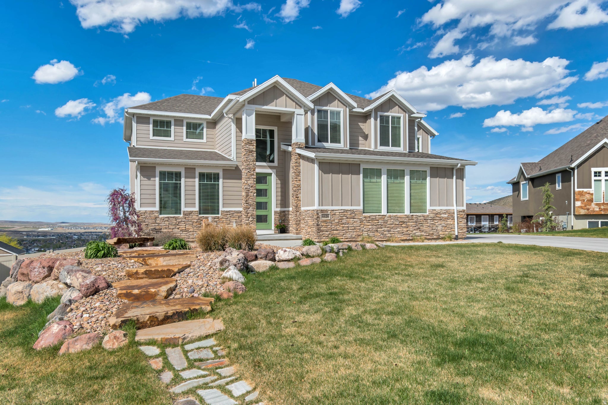 Two-story property featuring a stone and siding facade